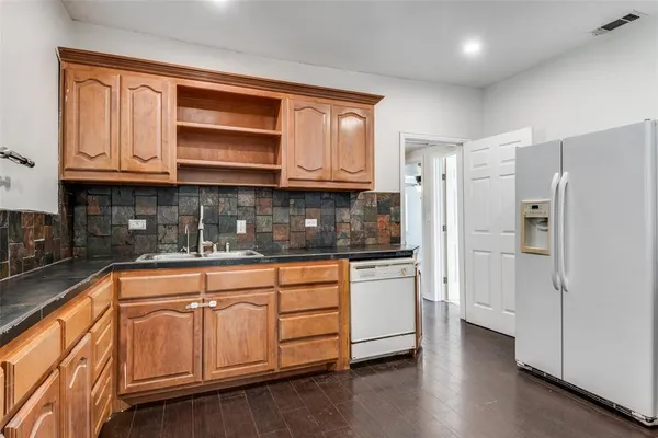 a kitchen with stainless steel appliances granite countertop a refrigerator and cabinets