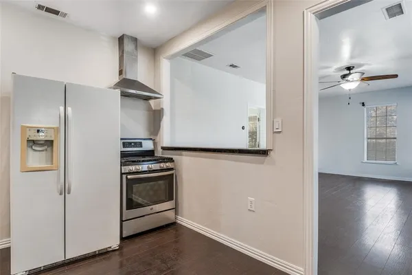 a kitchen with a stove and a wooden floor