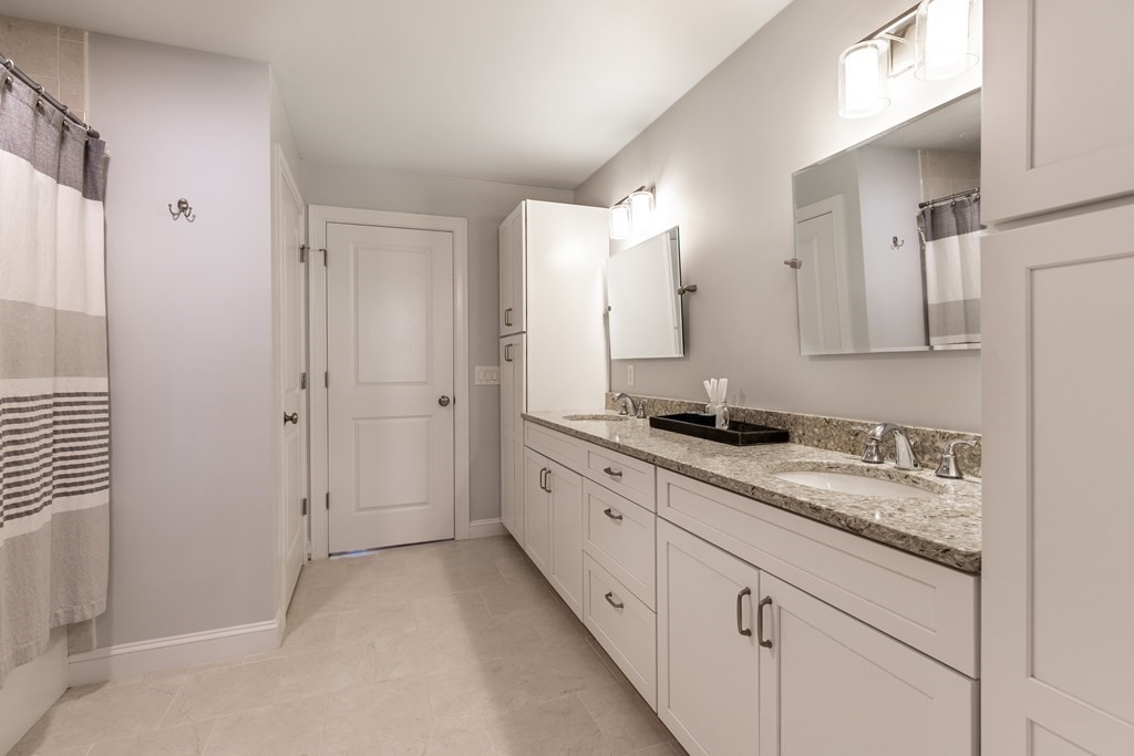 176 Main Street, Unit 3 Medway, MA 02053 - Photo 15 of 28 a spacious bathroom with a granite countertop sink and a mirror