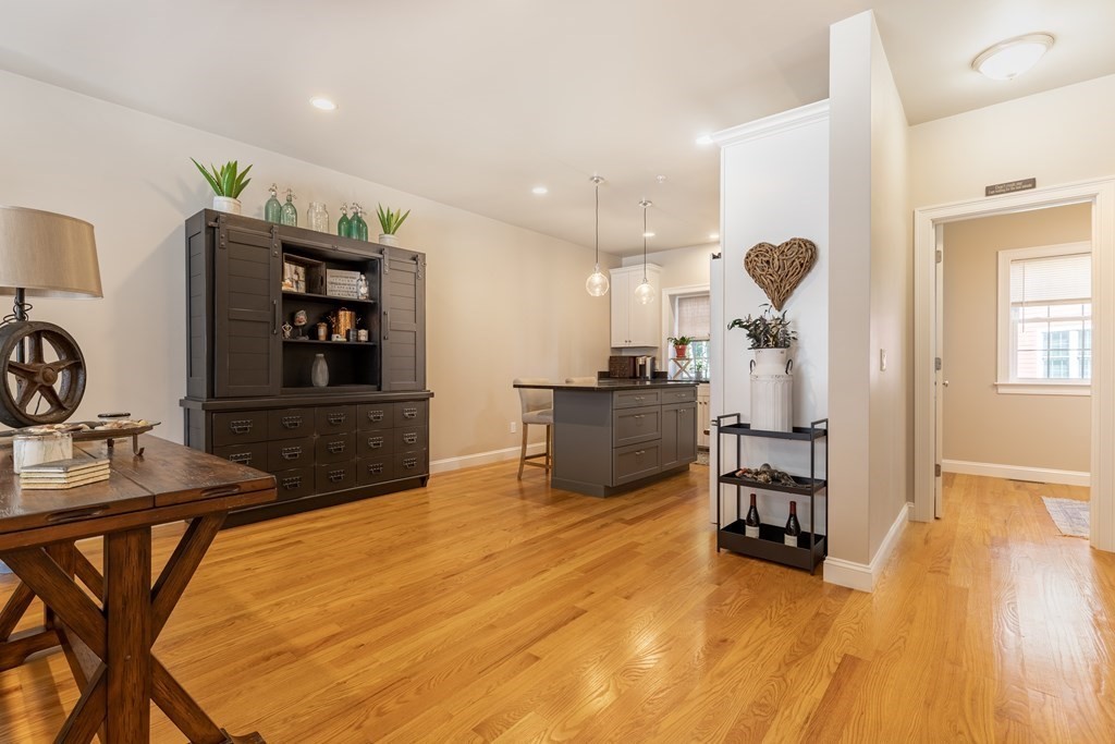 176 Main Street, Unit 3 Medway, MA 02053 - Photo 6 of 28 a kitchen with stainless steel appliances kitchen island granite countertop a table chairs in it and wooden floors