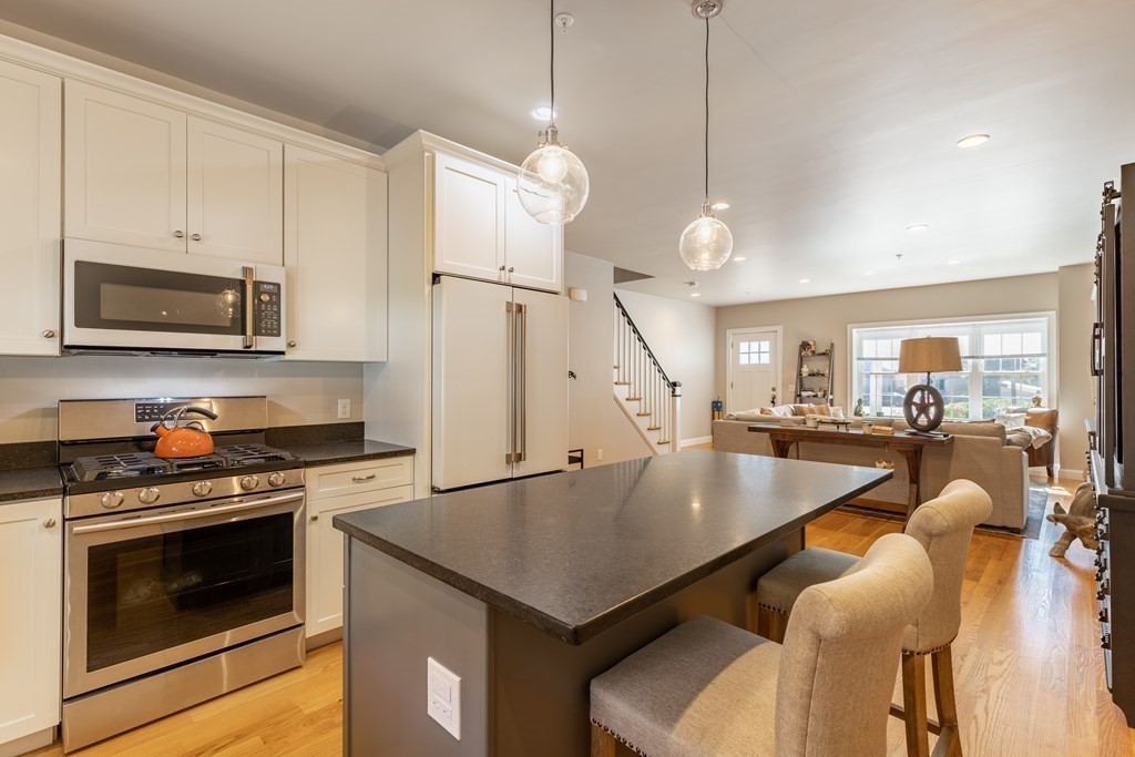 176 Main Street, Unit 3 Medway, MA 02053 - Photo 10 of 28 a kitchen with stainless steel appliances granite countertop a stove a refrigerator a oven a sink a stove and white cabinets