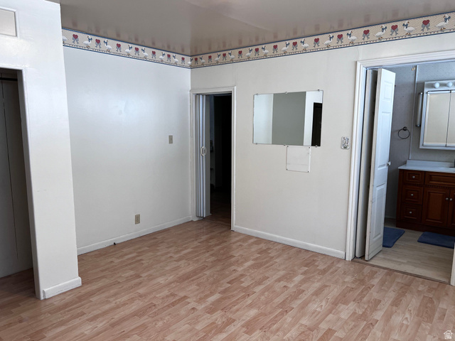 338 South 300 West Helper, UT 84526 - Photo 12 of 20 Unfurnished bedroom featuring light wood finished floors and connected bathroom