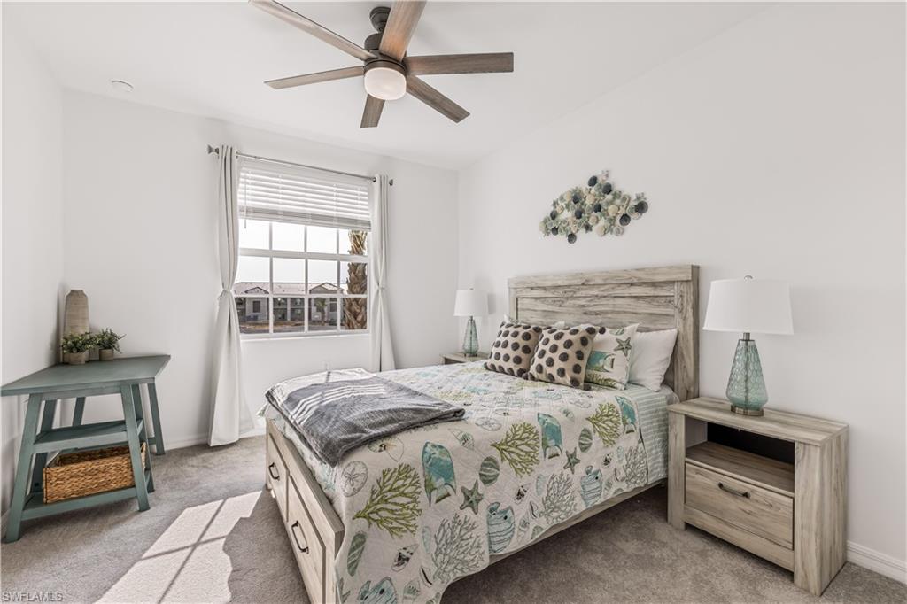 43997 Boardwalk Loop, Unit 1821 Babcock Ranch, FL 33982 - Photo 12 of 14 a bedroom with a bed and a chandelier