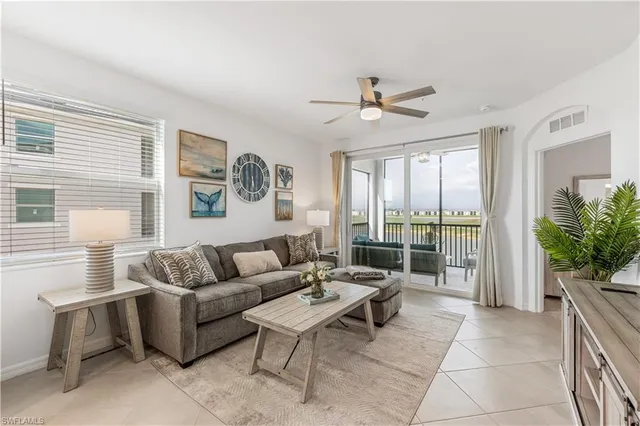 a living room with furniture potted plant and a large window