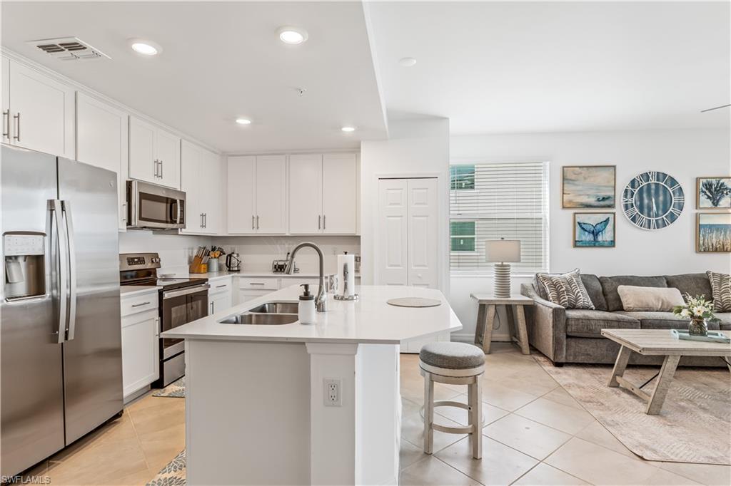 43997 Boardwalk Loop, Unit 1821 Babcock Ranch, FL 33982 - Photo 6 of 14 a kitchen with stainless steel appliances kitchen island granite countertop a sink and cabinets