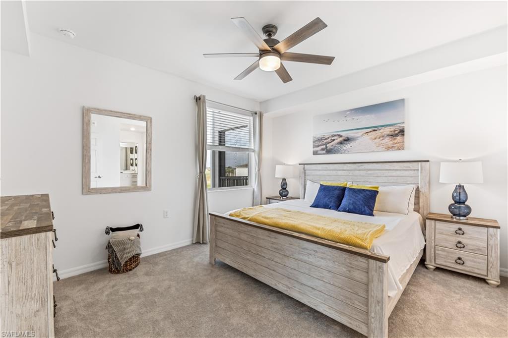 43997 Boardwalk Loop, Unit 1821 Babcock Ranch, FL 33982 - Photo 8 of 14 a bedroom with a bed a bed and a chandelier