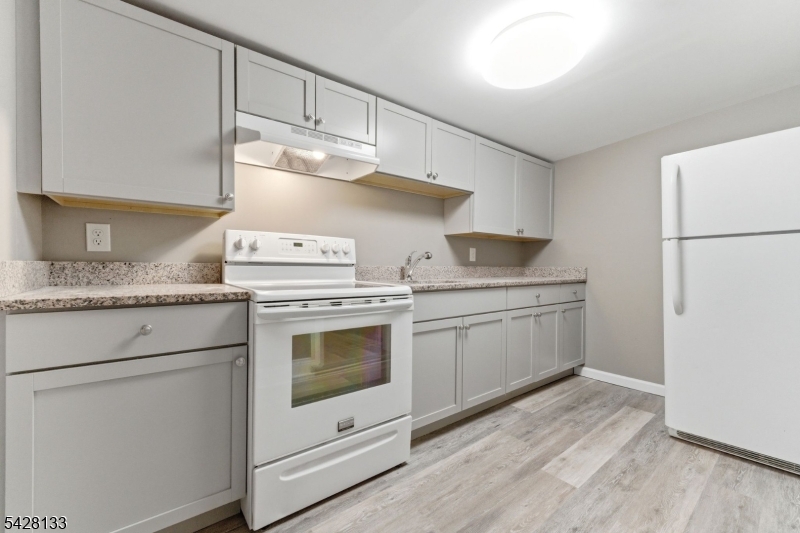 58 Bridge Street Milford, NJ 08848 - Photo 4 of 13 a kitchen with granite countertop white cabinets and white appliances