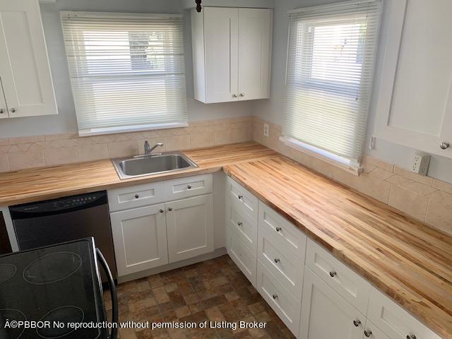 217 Malverne Road West Palm Beach, FL 33405 - Photo 2 of 9 a kitchen with a sink stove and cabinets