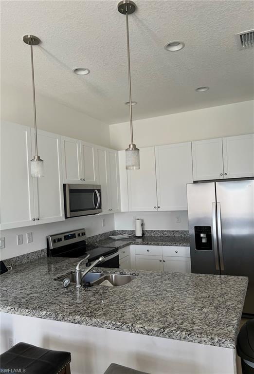 5474 Cassidy Lane Ave Maria, FL 34142 - Photo 4 of 31 a kitchen with kitchen island granite countertop a sink a counter top space appliances and cabinets