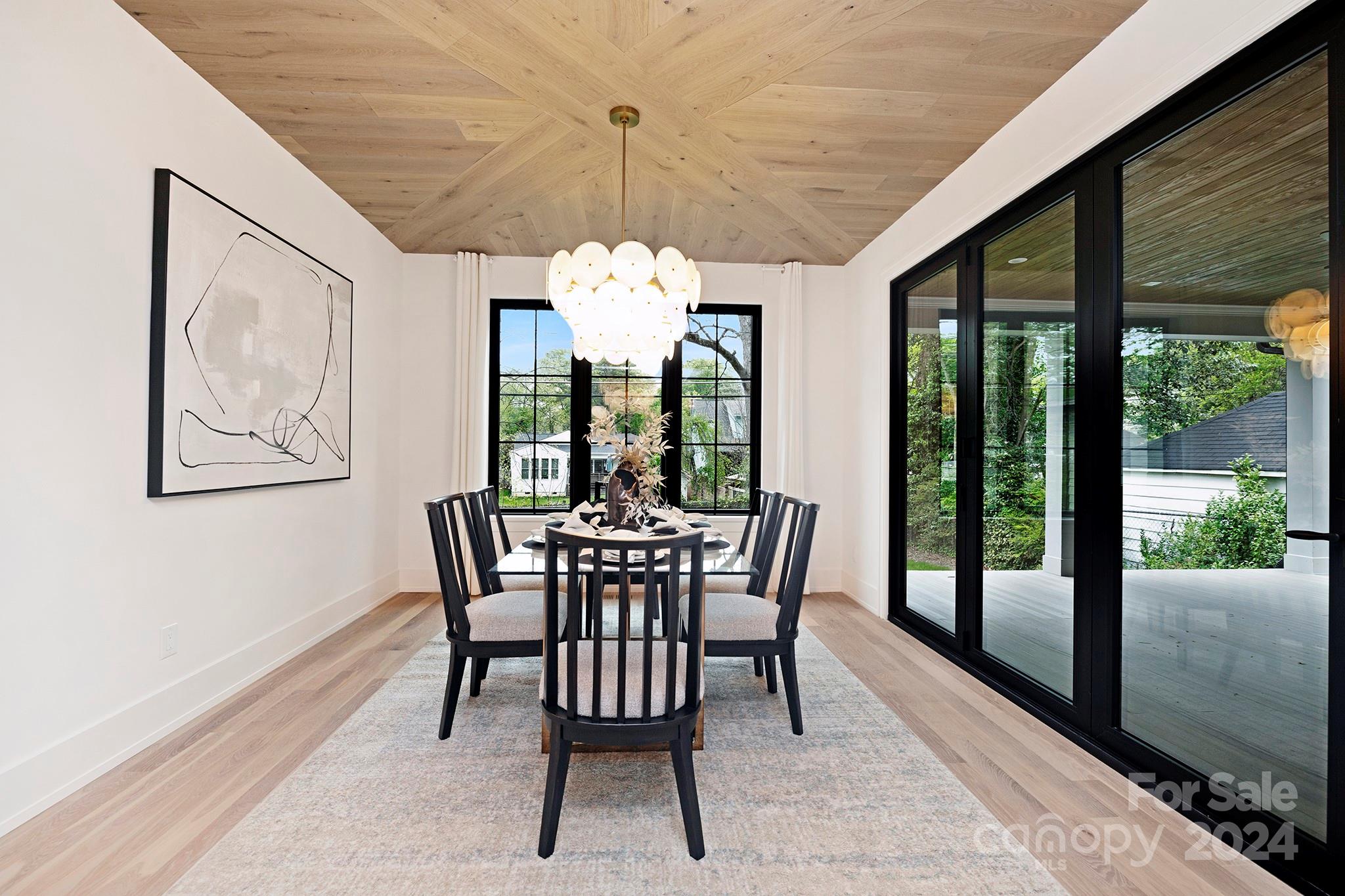 1815 Club Road Charlotte, NC 28205 - Photo 22 of 42 a view of a dining room with furniture a chandelier and large windows