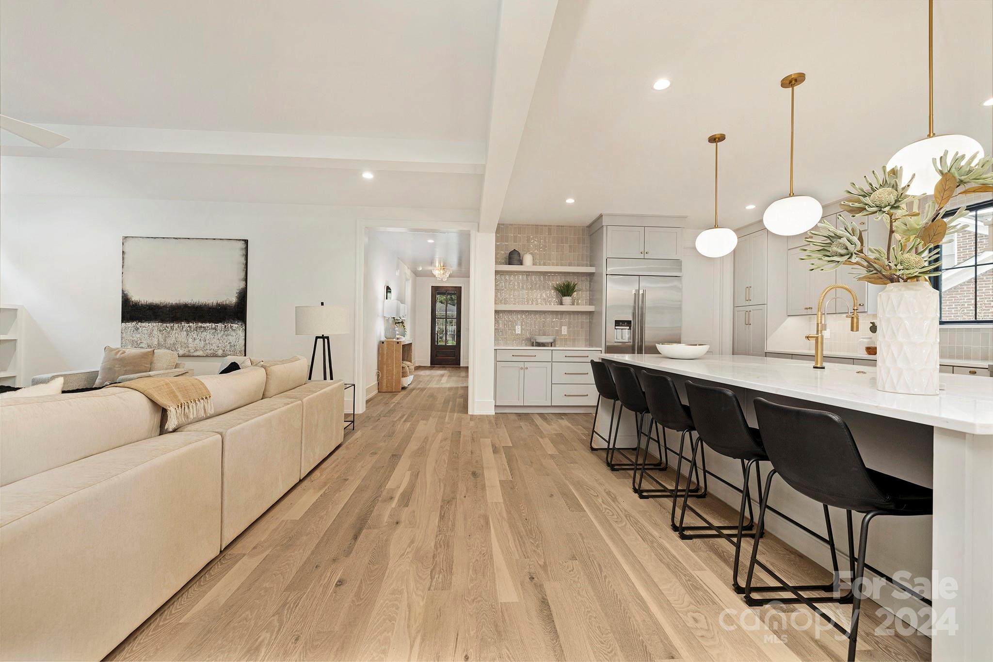 1815 Club Road Charlotte, NC 28205 - Photo 10 of 42 a large living room with stainless steel appliances kitchen island granite countertop a table chairs and a wooden floor