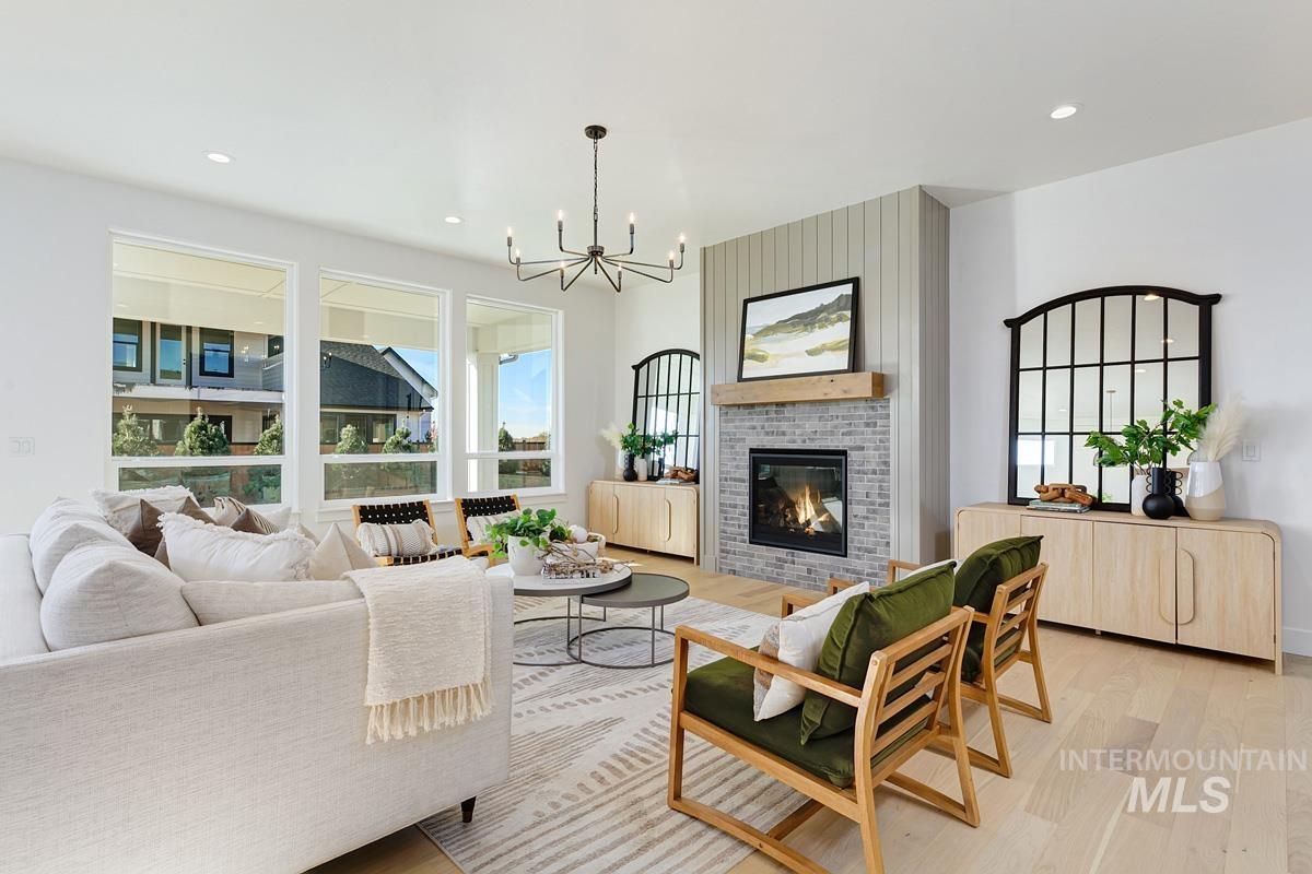 21895 Paint Avenue Star, ID 83669 - Photo 4 of 35 Living area featuring a fireplace, light wood-style flooring, recessed lighting, and a chandelier