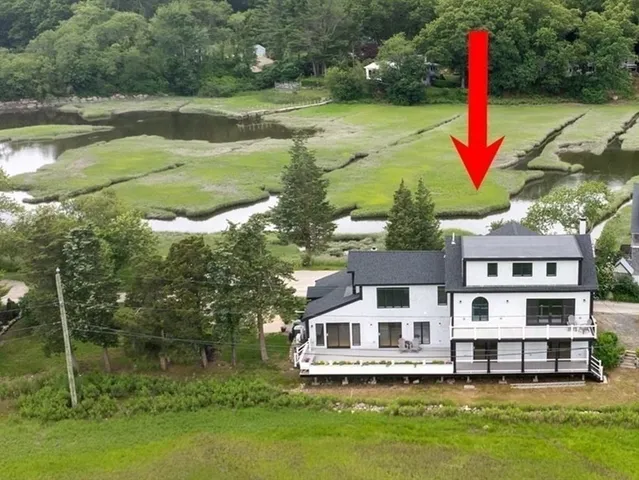 a view of a lake with a big yard and large trees