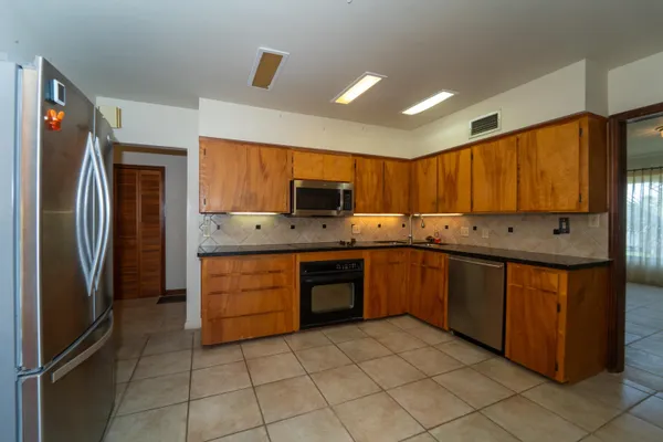 a kitchen with stainless steel appliances granite countertop a refrigerator and a stove top oven