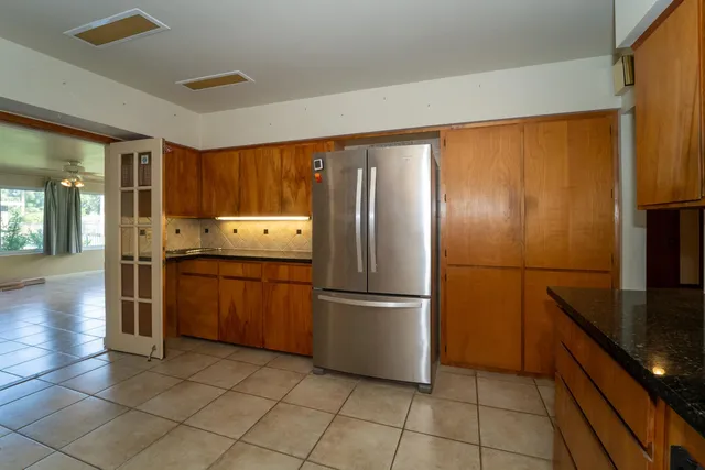 a kitchen with granite countertop a refrigerator and a sink