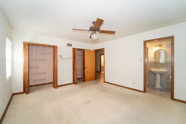 a view of a livingroom with a chandelier fan and windows