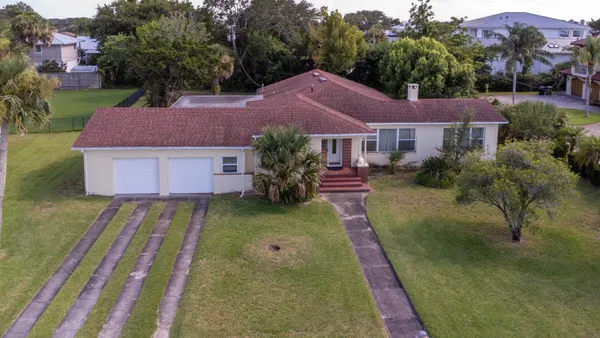 a view of a house with a big yard and a garden