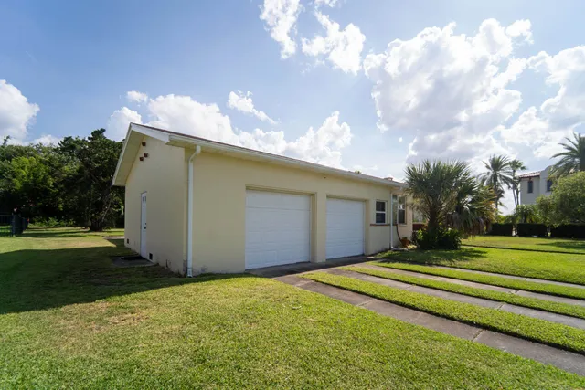 a front view of house with yard and trees in the background