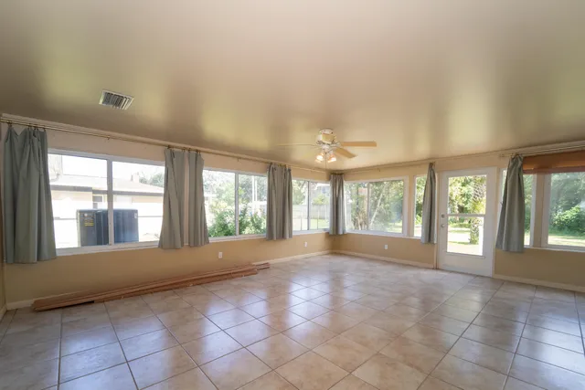 a view of an empty room with a large window and front door