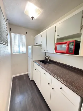 a kitchen with stainless steel appliances granite countertop a sink and wooden floor