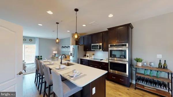 a kitchen with stainless steel appliances kitchen island granite countertop a refrigerator a stove a kitchen island a dining table and chairs