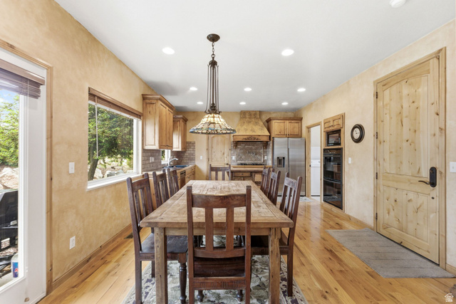 3634 North Huntsman Path, Unit C203 Eden, UT 84310 - Photo 5 of 27 Spacious kitchen and dining area featuring wood-finish flooring, recessed lighting, wood cabinetry, a tile backsplash, and stainless steel appliances
