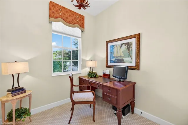 a view of a workspace with furniture and a window