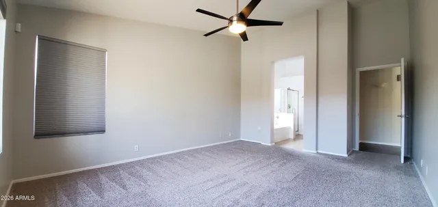 an empty room with a window and a ceiling fan
