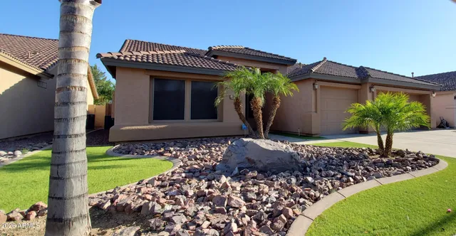 a front view of a house with a garden