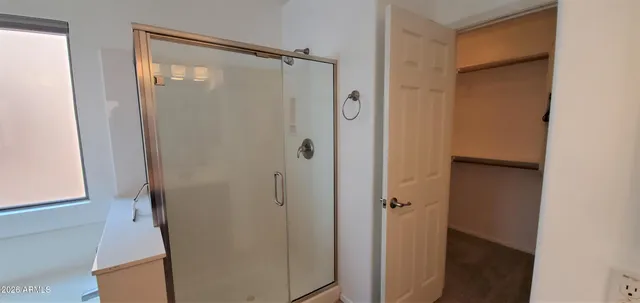 a bathroom with a glass door shower and a sink