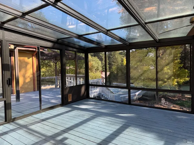 a view of an empty room with wooden floor and a bathroom