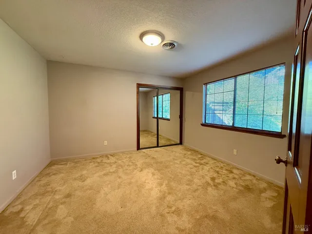 an empty room with windows and closet