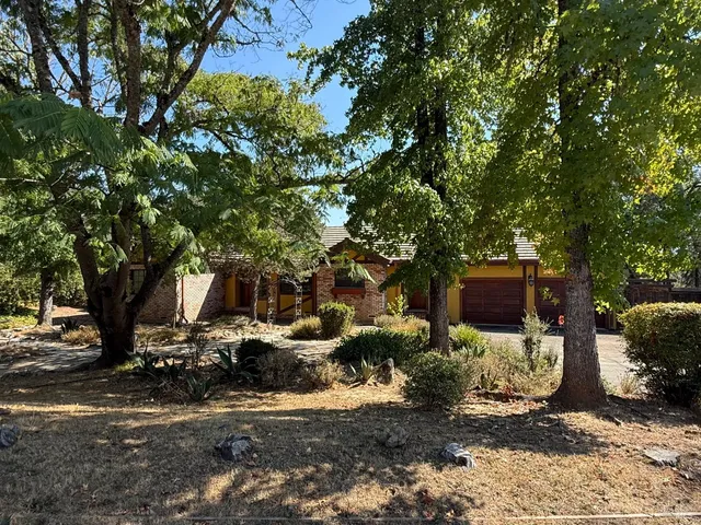 a backyard of a house with barbeque oven and outdoor seating