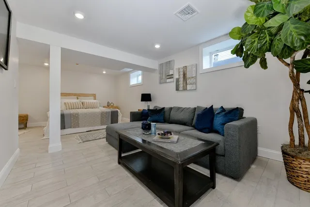 a living room with furniture a chandelier a rug and a window