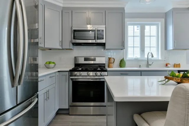 a kitchen with stainless steel appliances a stove microwave and sink