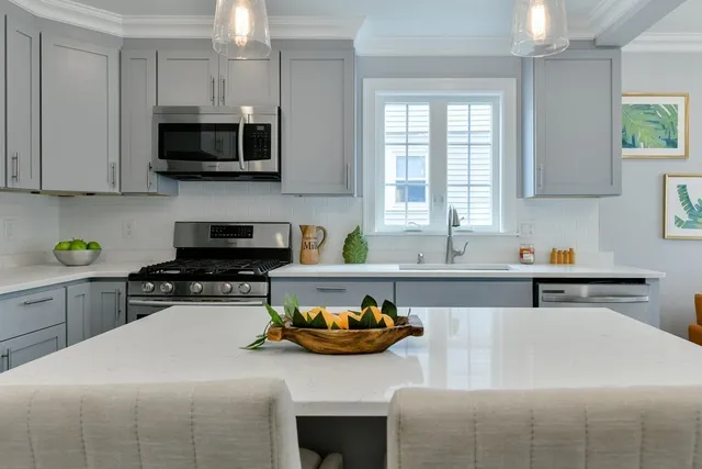 a kitchen with stainless steel appliances a stove a sink a microwave and cabinets