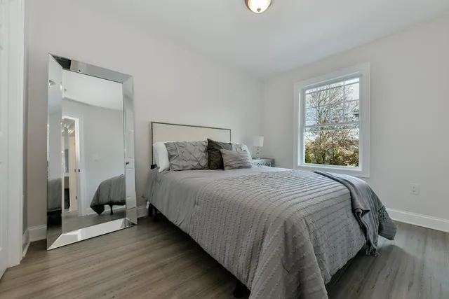 a bedroom with a bed and wooden floor