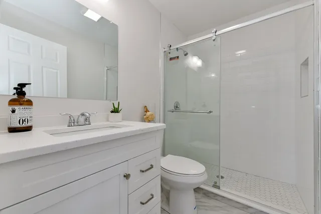 a bathroom with a sink a toilet and shower