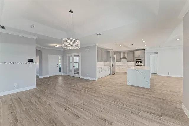 a view of kitchen and hall with wooden floor