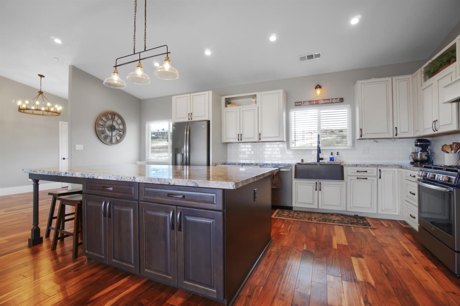 7991 South Shingle Road Shingle Springs, CA 95682 - Photo 11 of 58 a kitchen with wooden floors and white cabinets