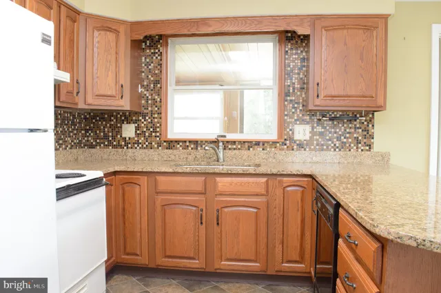 a bathroom with granite countertop a sink a vanity and a window