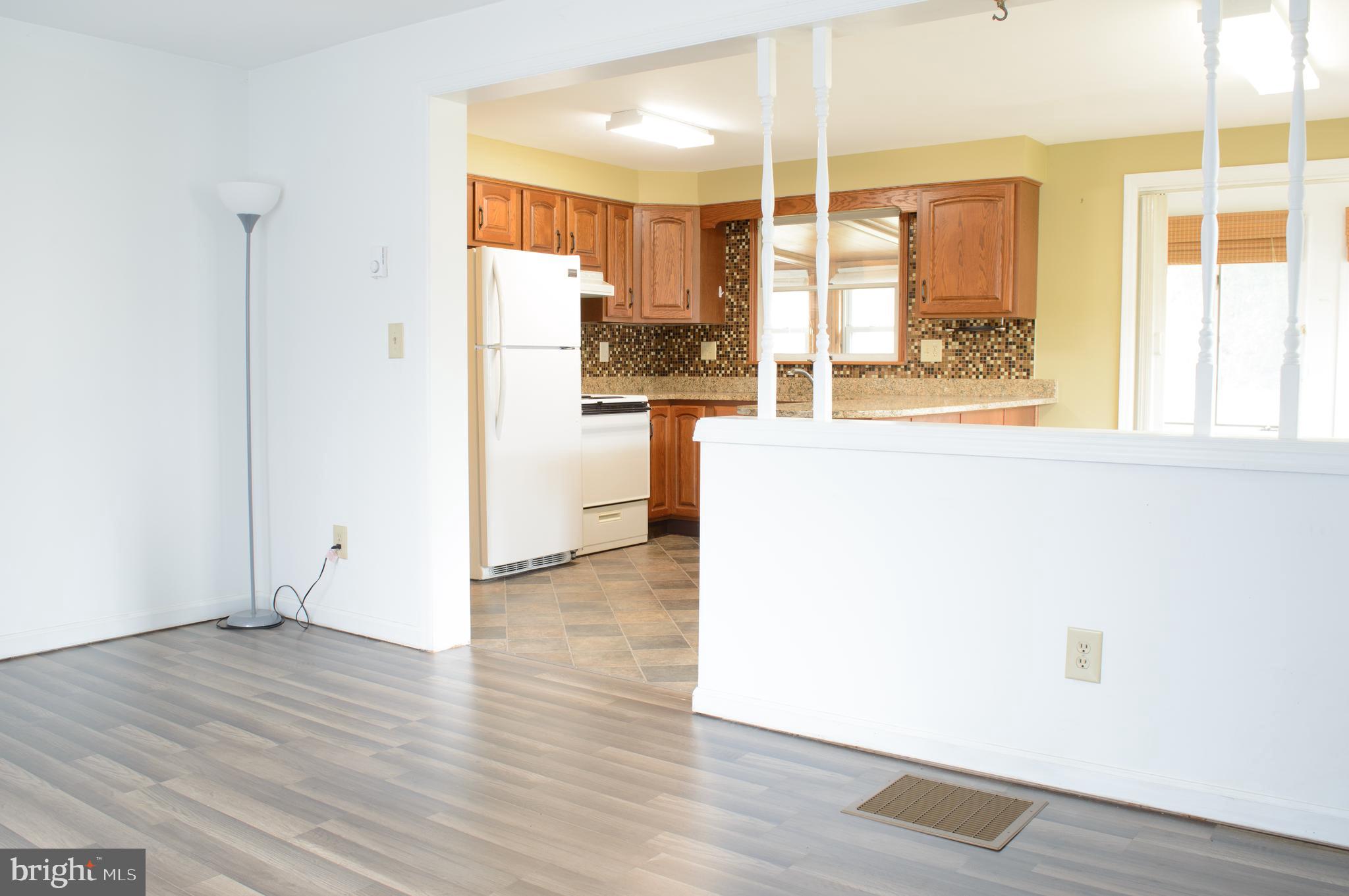 12713 Winchester Road Cumberland, MD 21502 - Photo 23 of 55 a view of a living room with a large window wooden floor and a kitchen view