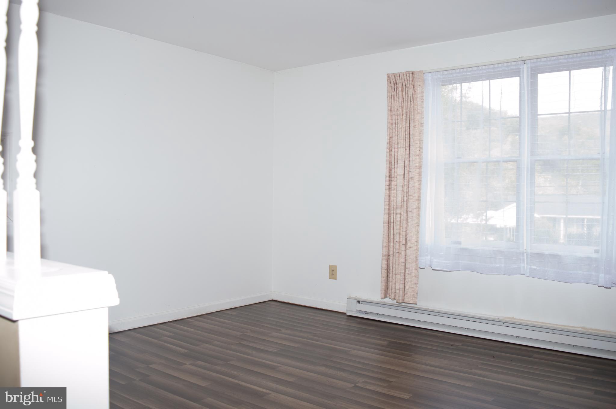 12713 Winchester Road Cumberland, MD 21502 - Photo 31 of 55 an empty room with wooden floor and windows