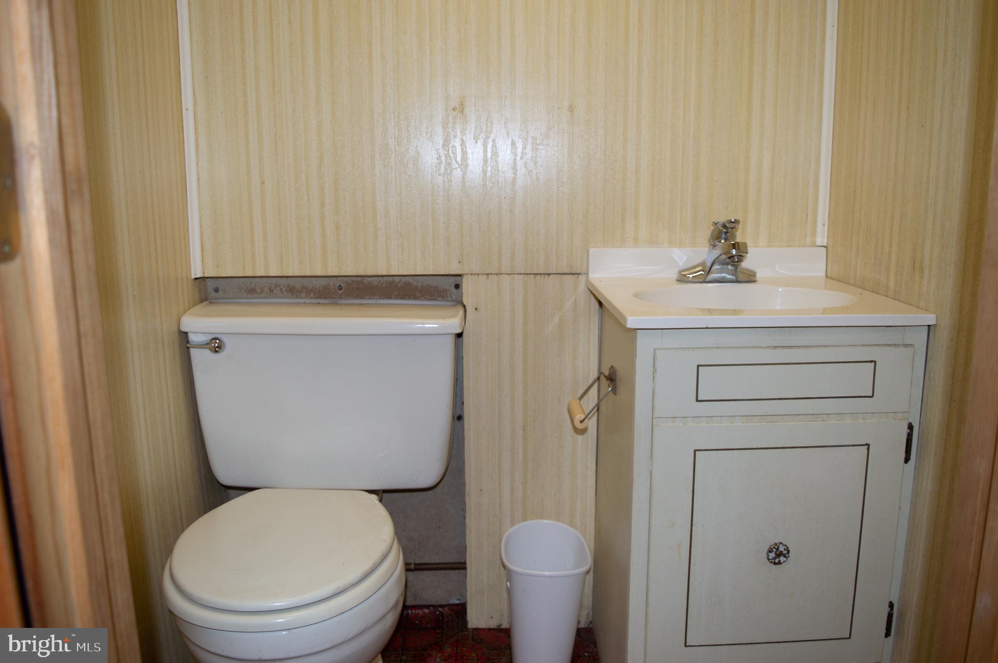 12713 Winchester Road Cumberland, MD 21502 - Photo 49 of 55 a bathroom with a toilet a sink and mirror
