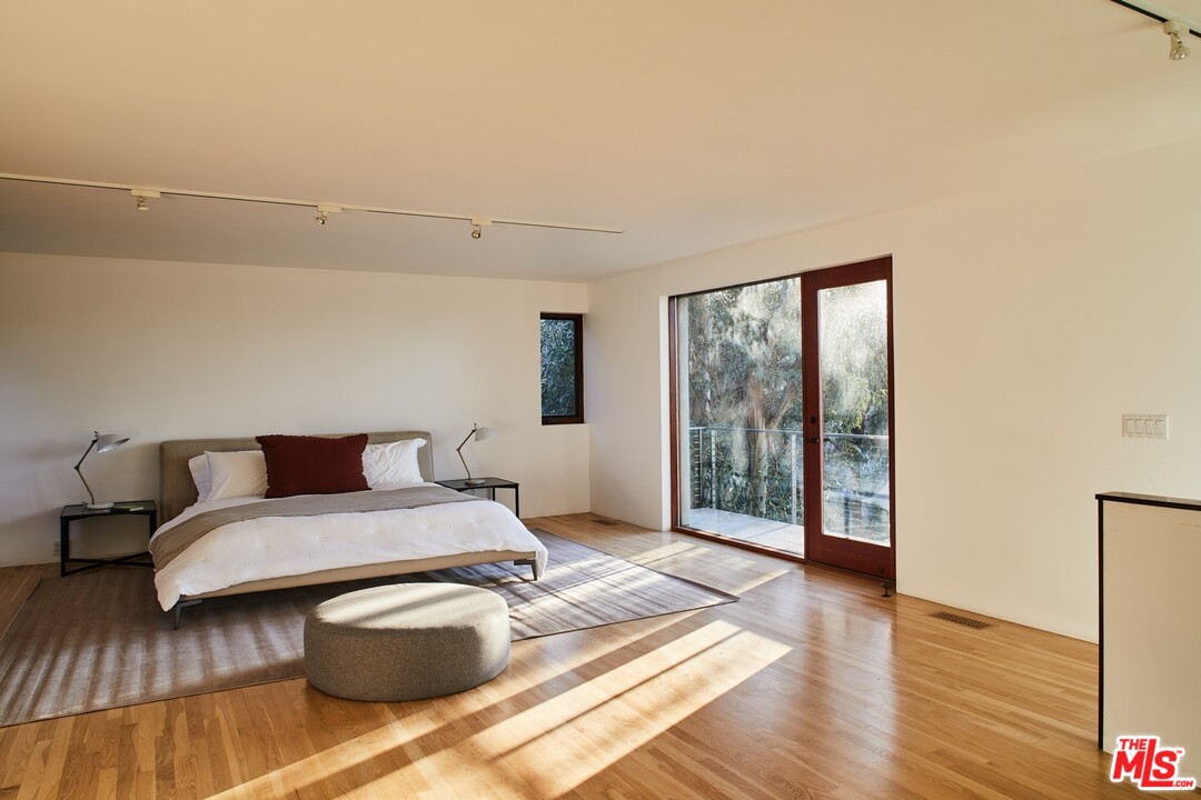 3201 Coldwater Canyon Lane Beverly Hills, CA 90210 - Photo 17 of 23 a bedroom with a bed and wooden floor