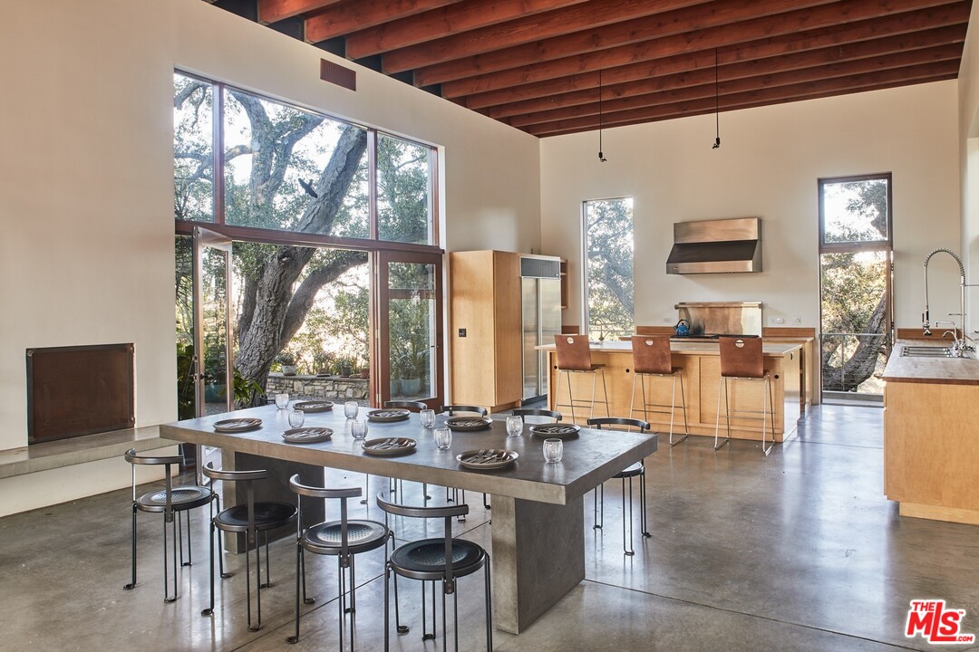 3201 Coldwater Canyon Lane Beverly Hills, CA 90210 - Photo 8 of 23 a view of a dining room with furniture wooden floor and a large window
