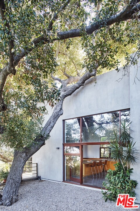 3201 Coldwater Canyon Lane Beverly Hills, CA 90210 - Photo 9 of 23 a backyard of a house with table and chairs under an umbrella