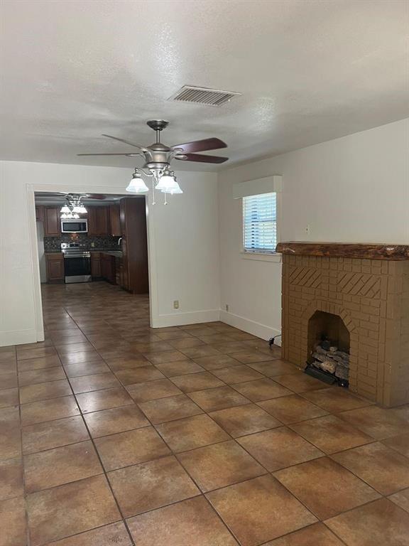 1209 Bawcom Street Sweetwater, TX 79556 - Photo 2 of 10 a view of a livingroom with a fireplace and a chandelier