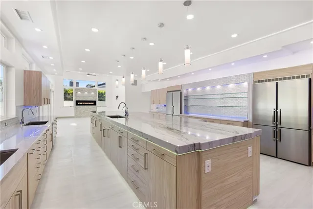 a kitchen with stainless steel appliances granite countertop a sink a stove a refrigerator and cabinets