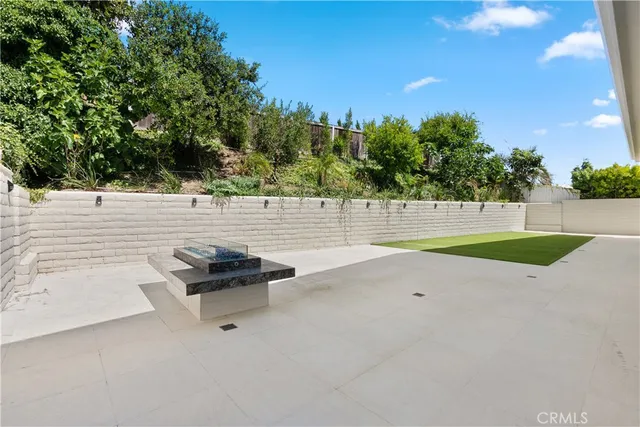 a view of empty room with kitchen and window